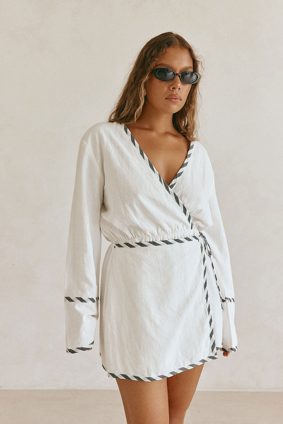 White mini dress with a wrap silhouette, detail view