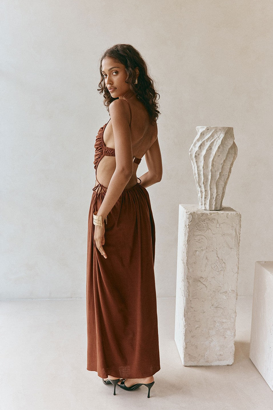 Brown maxi dress with an open back, styled on model