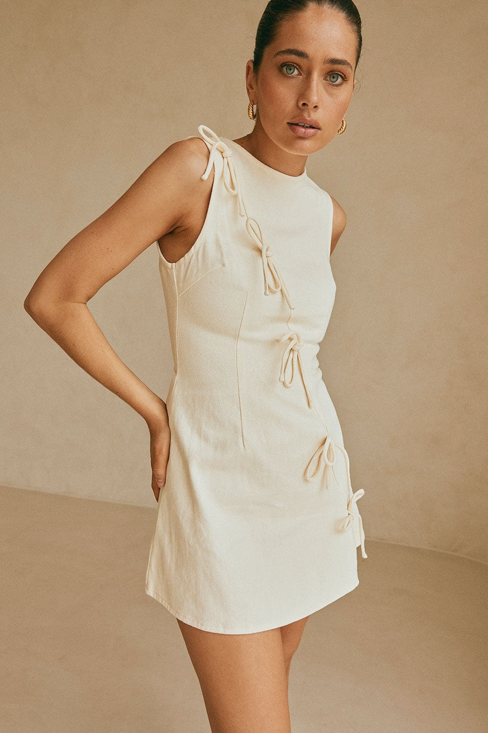 Cream mini dress with an A-line skirt, styled on model