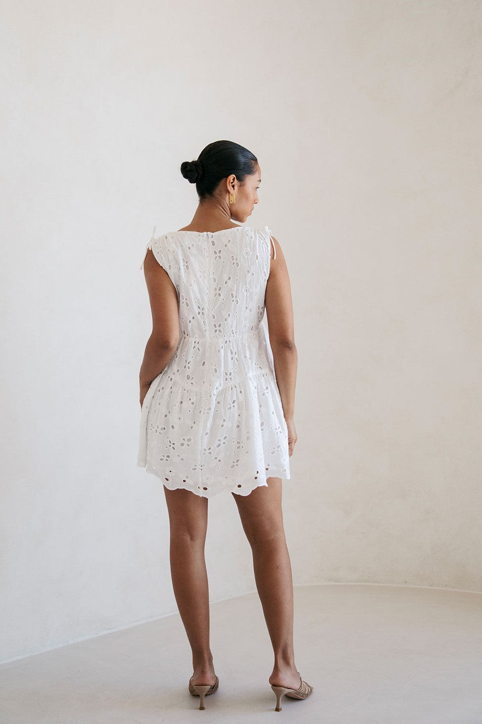 White mini dress with a V neckline, side view