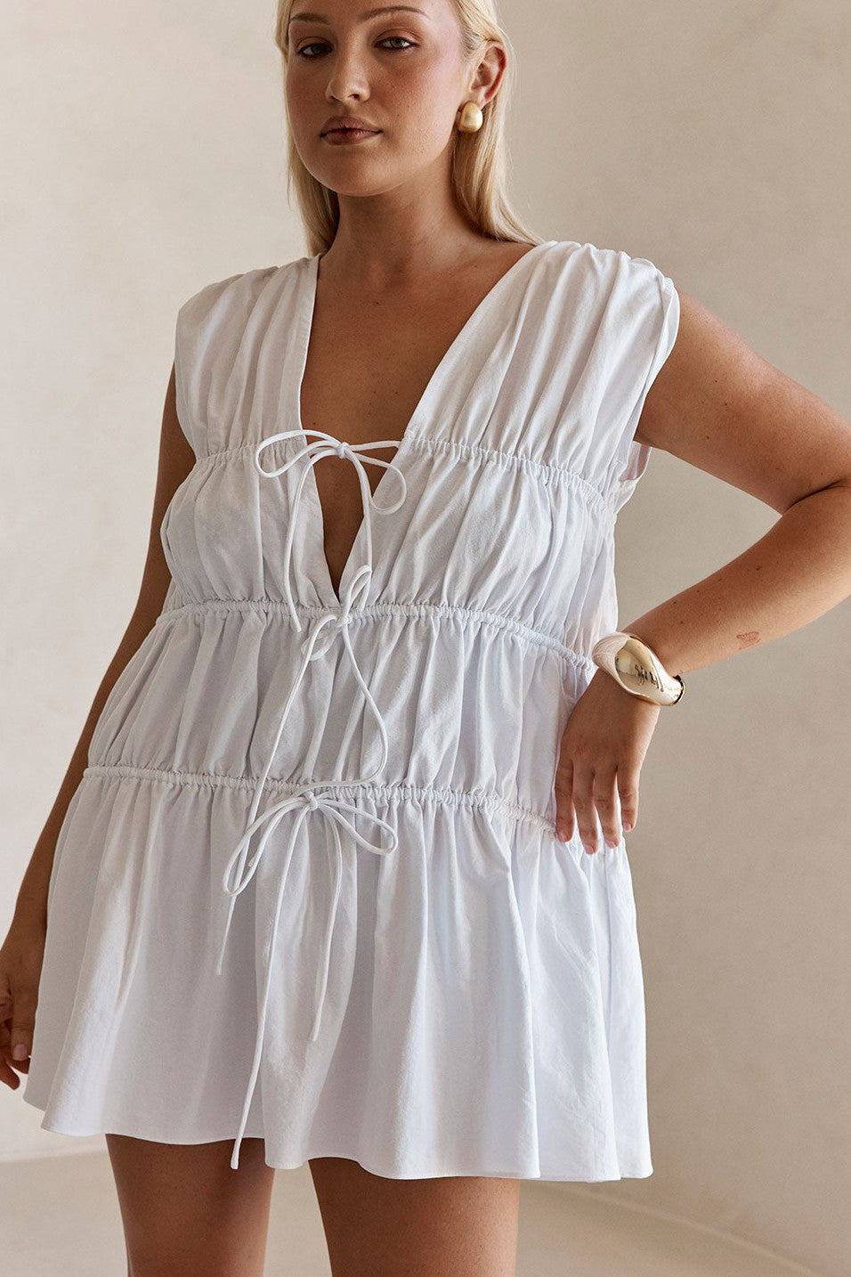 White mini dress with a V neckline, detail view