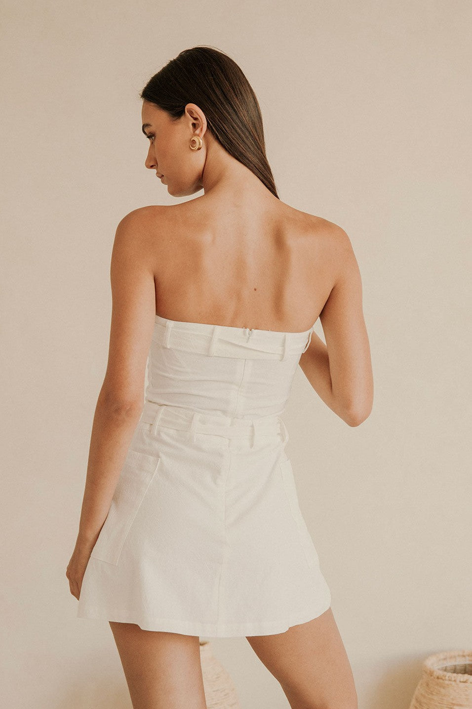 White mini dress with a strapless neckline, styled on model